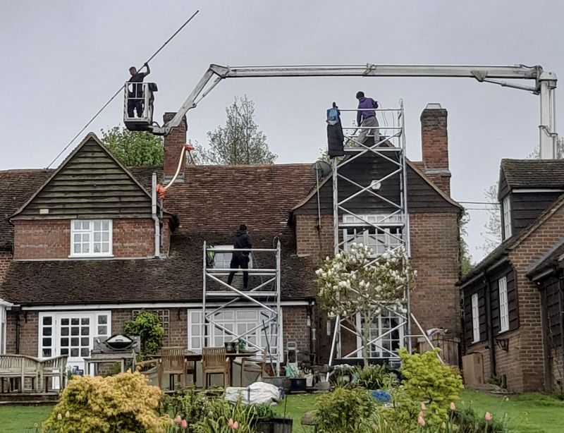 The Moss Cleaners using cherry picker and scaffolding to clean roof safely and professionally in Horley, Surrey